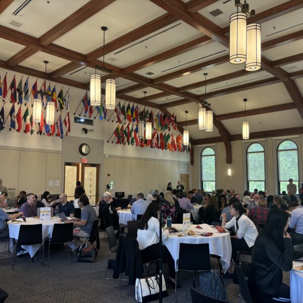 Medium conference with audience sitting around round tables.